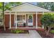 A cozy covered brick front porch with seating and decorative wreath welcomes visitors at 2703 Carolyn Se Dr, Smyrna, GA 30080