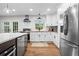 Well-lit kitchen with stainless steel appliances, island with seating, and wood floors at 2703 Carolyn Se Dr, Smyrna, GA 30080