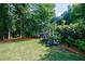 Serene backyard featuring lush greenery, mature trees, and vibrant hydrangea bushes at 5004 Haralson Sw Way, Lilburn, GA 30047