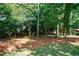 A view of the property with fencing, tall trees, and a pine straw-covered ground at 5004 Haralson Sw Way, Lilburn, GA 30047