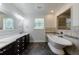 Luxurious bathroom features a soaking tub, decorative windows, and stylish tiled shower with stone accents at 5004 Haralson Sw Way, Lilburn, GA 30047