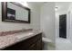 Well-lit bathroom with granite vanity, framed mirror, and beadboard paneling at 5004 Haralson Sw Way, Lilburn, GA 30047