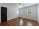 Bright bedroom with hardwood floors, two shuttered windows, and a dark paneled door at 5004 Haralson Sw Way, Lilburn, GA 30047