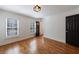 Bright bedroom featuring hardwood floors, plantation shutters, and modern light fixture at 5004 Haralson Sw Way, Lilburn, GA 30047
