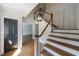 Foyer with hardwood floors, white banister staircase, and decorative lighting at 5004 Haralson Sw Way, Lilburn, GA 30047