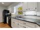 Renovated kitchen with stainless steel appliances, white cabinets, and granite countertops with natural sunlight at 5004 Haralson Sw Way, Lilburn, GA 30047