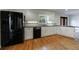Updated kitchen featuring black appliances, granite countertops, and white cabinets with hardwood floors at 5004 Haralson Sw Way, Lilburn, GA 30047