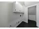 Clean laundry area featuring white cabinets for storage and black tile flooring at 5004 Haralson Sw Way, Lilburn, GA 30047