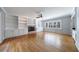 Bright living room featuring built-in shelves, a fireplace, hardwood floors, and plantation shutters at 5004 Haralson Sw Way, Lilburn, GA 30047