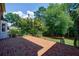 Brick patio offering outdoor entertaining space with mature trees and landscaping views at 5004 Haralson Sw Way, Lilburn, GA 30047
