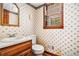 Small bathroom featuring floral wallpaper, vanity with sink, toilet, mirror, and a window at 5419 Ahyoka Dr, Morrow, GA 30260