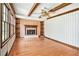 Living room with hardwood floors, built-in shelves, stone fireplace, a ceiling fan, and wood ceiling beams at 5419 Ahyoka Dr, Morrow, GA 30260