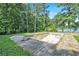An in-ground pool with diving board nestled in a backyard with mature trees and a swing set at 5419 Ahyoka Dr, Morrow, GA 30260