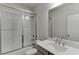 Modern bathroom features tiled shower over tub, with a gray vanity at 1459 Bennett Creek Ovlk, Suwanee, GA 30024