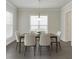 Neutral dining room featuring hardwood floors, a window, and modern light fixture above table with seating for six at 1459 Bennett Creek Ovlk, Suwanee, GA 30024