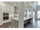 Modern, open-concept kitchen featuring white cabinets, stainless steel appliances, and a quartz countertop island at 1459 Bennett Creek Ovlk, Suwanee, GA 30024