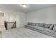 Bright living room features neutral carpeting, a gray sofa, and access to stairs at 1459 Bennett Creek Ovlk, Suwanee, GA 30024