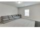 Inviting living room with a comfortable gray couch and soft, neutral carpeting at 1459 Bennett Creek Ovlk, Suwanee, GA 30024