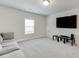 Spacious living room with cozy gray couch, large TV, and plush carpeting at 1459 Bennett Creek Ovlk, Suwanee, GA 30024