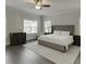 Comfortable primary bedroom featuring a plush king-size bed, soft carpet, and soothing gray tones for a relaxing ambiance at 1459 Bennett Creek Ovlk, Suwanee, GA 30024