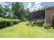 Spacious backyard with lush lawn, mature trees, a screened porch, and a chain link fence at 2880 Sherwood Se Rd, Smyrna, GA 30082