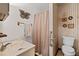 Cozy bathroom with floral wallpaper, vanity sink, and walk-in shower at 2880 Sherwood Se Rd, Smyrna, GA 30082