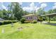 Well-maintained brick home featuring a lush green lawn, carport, and manicured landscaping at 2880 Sherwood Se Rd, Smyrna, GA 30082
