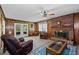 Inviting living room with brick fireplace, wood paneling and glass doors to the outside at 2880 Sherwood Se Rd, Smyrna, GA 30082