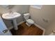 Half bathroom featuring pedestal sink, toilet, wood floors, and natural light from the window at 3618 Prescot Way, Douglasville, GA 30135