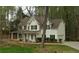 Traditional two-story home features a white exterior, black shutters and attached garage nestled among mature trees at 3618 Prescot Way, Douglasville, GA 30135