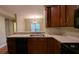 Kitchen with stainless steel sink, wooden cabinets, black appliances, and partial view of dining area at 3618 Prescot Way, Douglasville, GA 30135