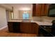 Kitchen with black appliances, wooden cabinets, and view of dining area with chandelier at 3618 Prescot Way, Douglasville, GA 30135
