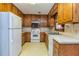 Kitchen featuring wood cabinets, white appliances, and tile flooring at 166 Muse Rd, Fayetteville, GA 30214