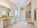 Bright bathroom featuring a large vanity, soaking tub with shower, and neutral tile floors at 5841 Cobalt Dr, Powder Springs, GA 30127
