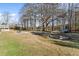 Large backyard featuring a fire pit, playset, grassy areas, and mature trees at 900 Stone Lea Trce, Oxford, GA 30054