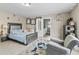 Bright bedroom featuring a blue bedspread, sitting area, and view into the en-suite bathroom at 900 Stone Lea Trce, Oxford, GA 30054