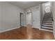 Hallway with hardwood floors, white doors, leading to stairs with a chandelier at 2118 Iverson Se Dr, Smyrna, GA 30080