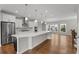 Bright open kitchen features white cabinets, stainless steel appliances, large island, and hardwood floors at 2118 Iverson Se Dr, Smyrna, GA 30080