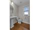 Charming powder room with pedestal sink, round mirror, and natural light from window at 2118 Iverson Se Dr, Smyrna, GA 30080