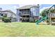 Spacious backyard featuring a screened-in porch, lush green lawn, and a play area with a slide at 2875 Daniel Park Run, Dacula, GA 30019