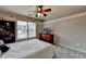 Comfortable bedroom featuring a ceiling fan, built-in bookcase, and neutral decor at 2875 Daniel Park Run, Dacula, GA 30019