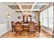 Elegant dining room features hardwood floors, chandelier, coffered ceiling, and large windows at 2875 Daniel Park Run, Dacula, GA 30019