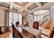 Formal dining room features hardwood floors, chandelier, coffered ceiling, and view to the entry at 2875 Daniel Park Run, Dacula, GA 30019
