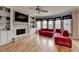 Spacious living room with hardwood flooring, fireplace, built-in shelving, and large windows at 2875 Daniel Park Run, Dacula, GA 30019