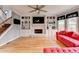Well-lit living room with hardwood floors, a fireplace, and built-in shelving at 2875 Daniel Park Run, Dacula, GA 30019