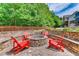 Community fire pit featuring stone benches and red Adirondack chairs at 1604 Gilstrap Nw Ln, Atlanta, GA 30318