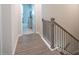 Hallway with wood floors leading to a bedroom and staircase with wooden handrail and iron balusters at 2247 Pink Hawthorn Dr, Buford, GA 30518