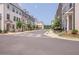 Beautiful street view of townhomes with sidewalks and mature trees at 2247 Pink Hawthorn Dr, Buford, GA 30518