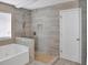 Bathroom showcasing a soaking tub and tiled walk-in shower with upgraded shower head and wood-look tile at 3725 Crescent Walk Ln, Suwanee, GA 30024