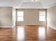 Spacious bedroom featuring hardwood floors, natural light, and ceiling fan with ample space for furniture at 3725 Crescent Walk Ln, Suwanee, GA 30024